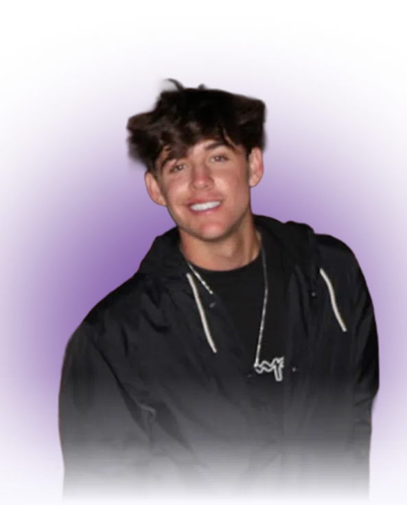 A smiling young man wearing a black hoodie and silver necklace, pictured against a light purple background with a soft white fade at the bottom.